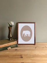 Load image into Gallery viewer, Tan elephant giclee cameo art print on white fine art paper shown in copper frame on table

