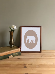 Tan elephant giclee cameo art print on white fine art paper shown in copper frame on table