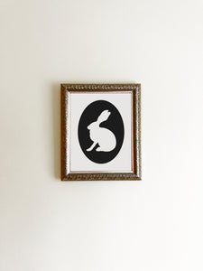 Black cameo rabbit giclee art print on white fine art paper shown hanging on wall in frame